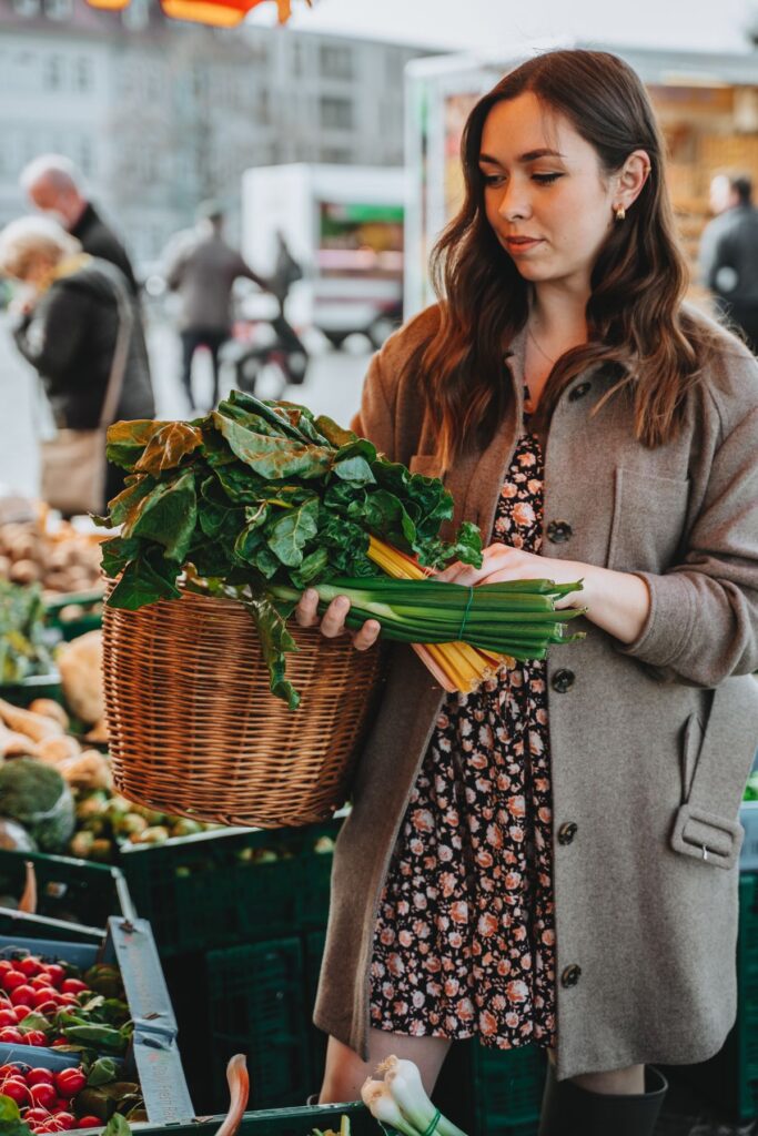 A woman choosing fresh vegetables at a market